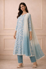 Powder blue floral kurta set side angle with ombre dupatta flow and neutral block heels.