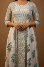 Woman wearing a floral patterned dress against a brown background