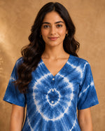 Close-up view of blue tie-dye A-line midi dress showing V-neckline, button placket, and detailed chevron pattern.