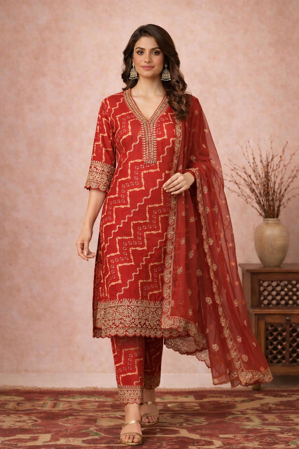SN150 women’s vermilion red Bandhani cotton silk kurta set walking pose with sheer dupatta and block heels.