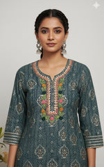 Woman wearing a traditional embroidered dress with a plain background