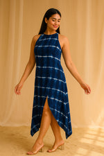 Side view of navy blue tie-dye asymmetrical midi dress with front slit and flowy hemline.