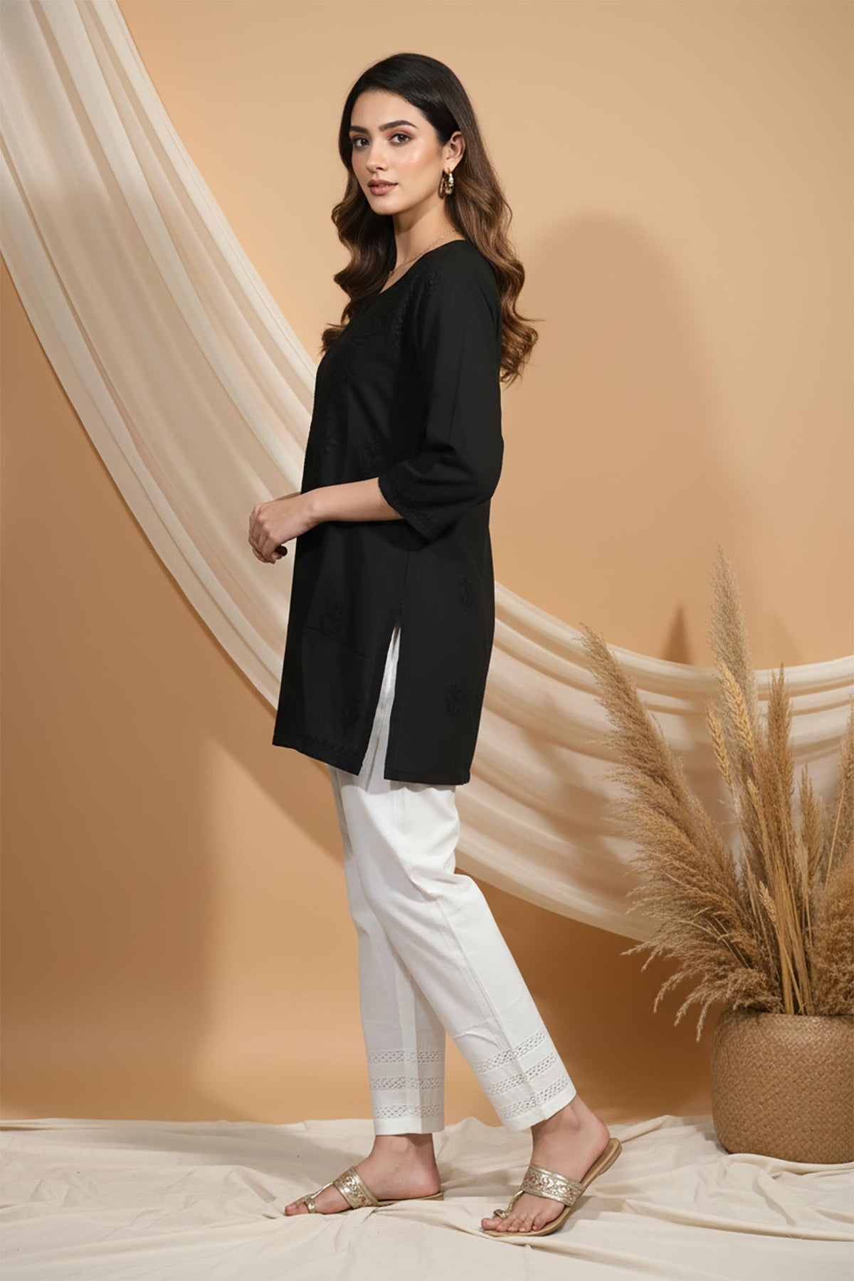 SN252 women’s black cotton embroidered short kurti with straight fit and three-quarter sleeves, side pose.