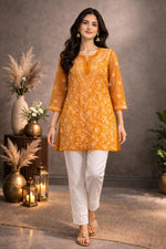 SN257 women’s mustard georgette chikankari kurti walking pose with floral embroidery and flowy silhouette