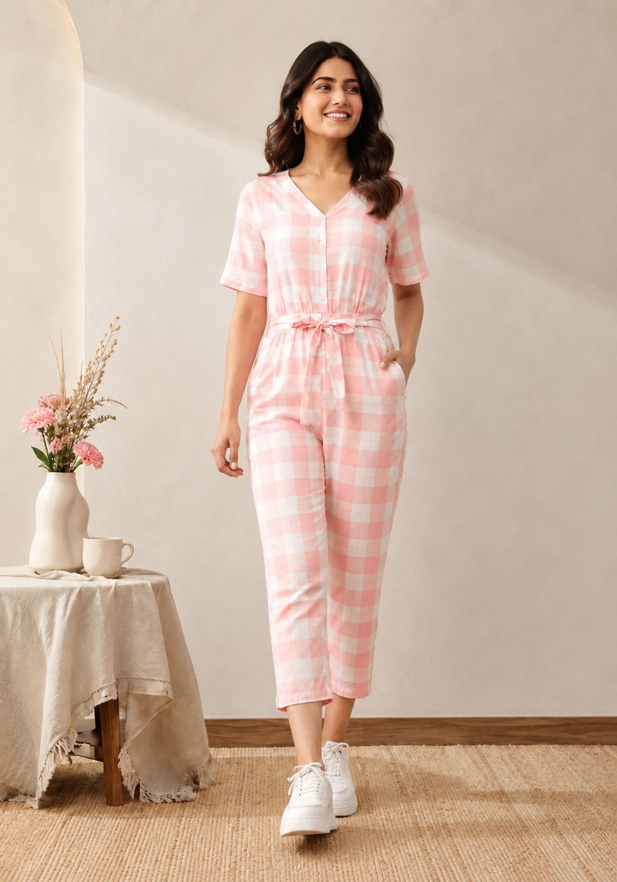 SN31 women’s pink gingham V-neck short sleeve jumpsuit with relaxed fit – walking pose