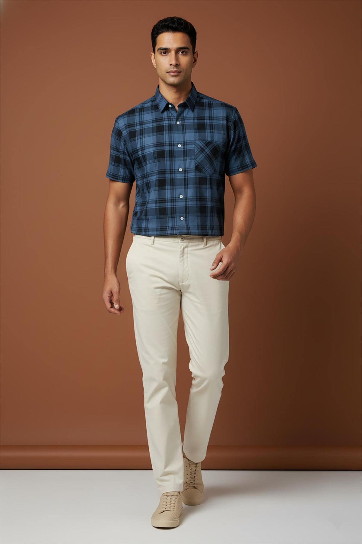 SN310 men’s midnight blue plaid short sleeve shirt walking pose styled with beige trousers and sneakers