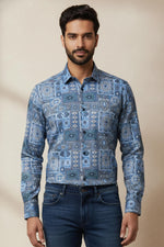 Close-up of blue geometric mosaic printed men’s shirt showing detailed tile pattern and button-down collar.