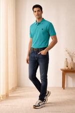 SN345 men’s turquoise cotton piqué polo t-shirt side pose, short sleeve, tailored fit, paired with dark denim