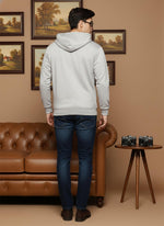 Light grey cotton zip hoodie back view featuring hood detail, ribbed hem, paired with dark denim and brown shoes.