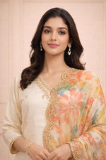 Ivory silk-blend kurta close-up, embroidered V-neckline, floral chiffon dupatta border, delicate earrings.