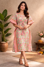 Woman wearing pastel green and pink floral cotton kaftan dress with tie-up waist and border detailing, full front view in studio setting