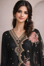 Black chiffon kurta close-up with gold embroidery, floral print, V-neck detail, delicate drop earrings.
