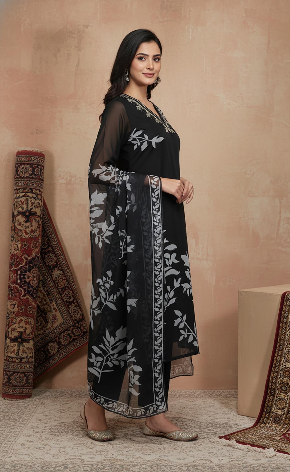 Side profile of black printed kurta set with flowing chiffon dupatta and traditional juttis.