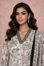 Off-white floral cotton kurta set close-up showing V-neckline, tassel tie and contrast trim.
