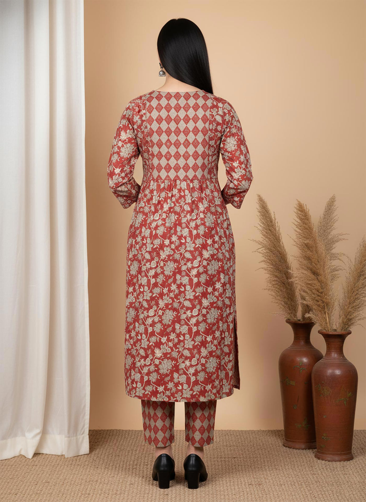 Back view terracotta floral kurta set with diamond pattern yoke and printed pants, paired with black heels.