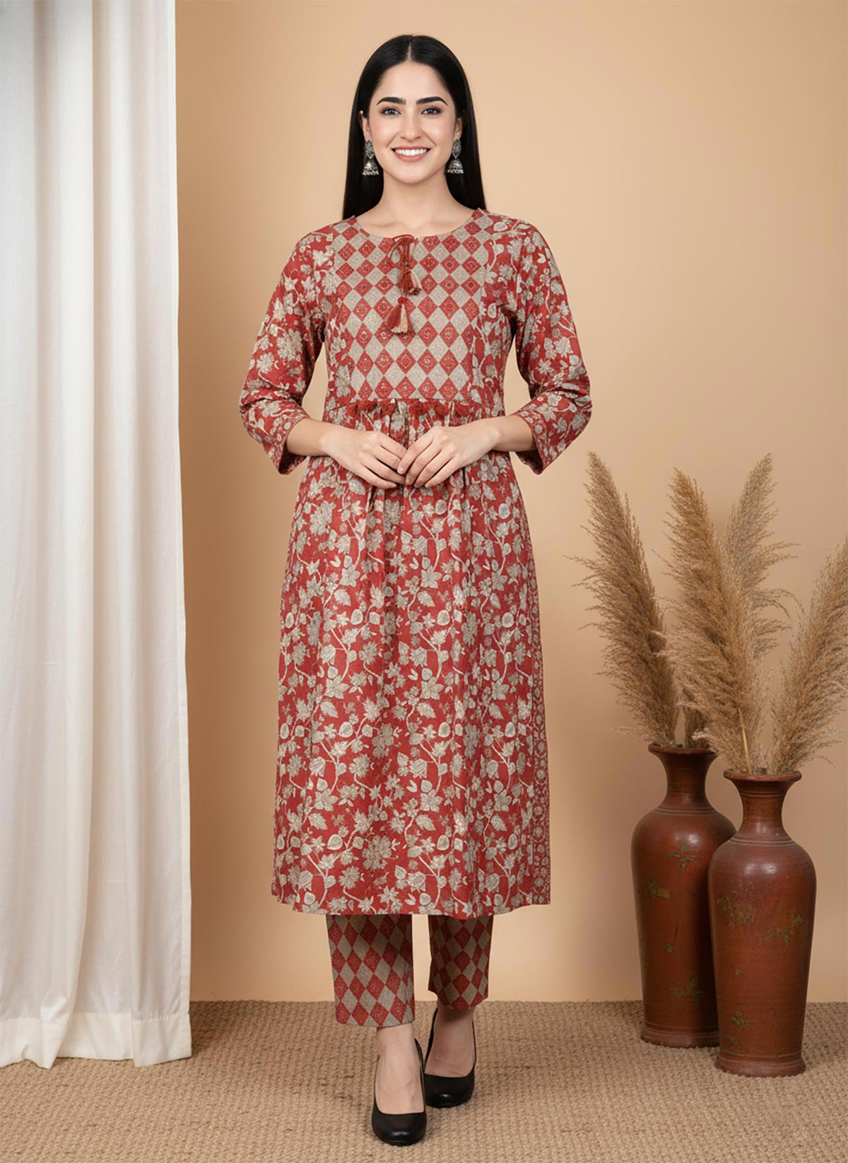 Front view terracotta floral kurta pant set with diamond yoke panel, three-quarter sleeves, styled with black heels.