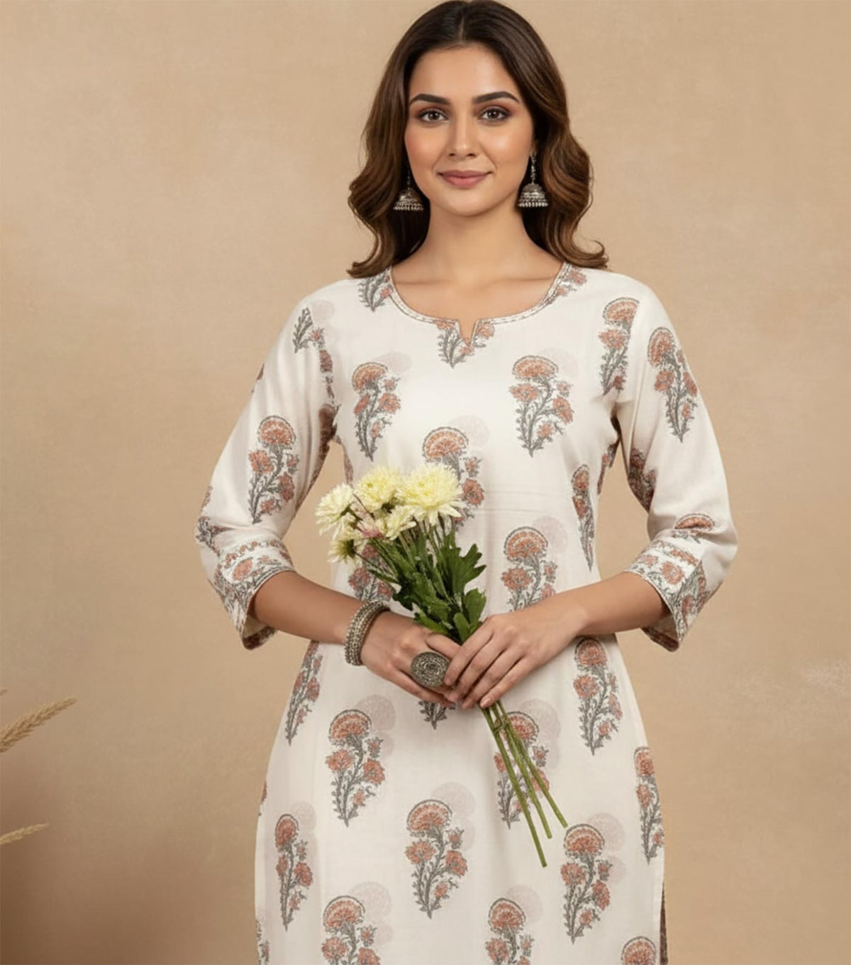 Close-up of ivory floral printed kurta with round neckline, delicate block print, three-quarter sleeves, holding white flowers.