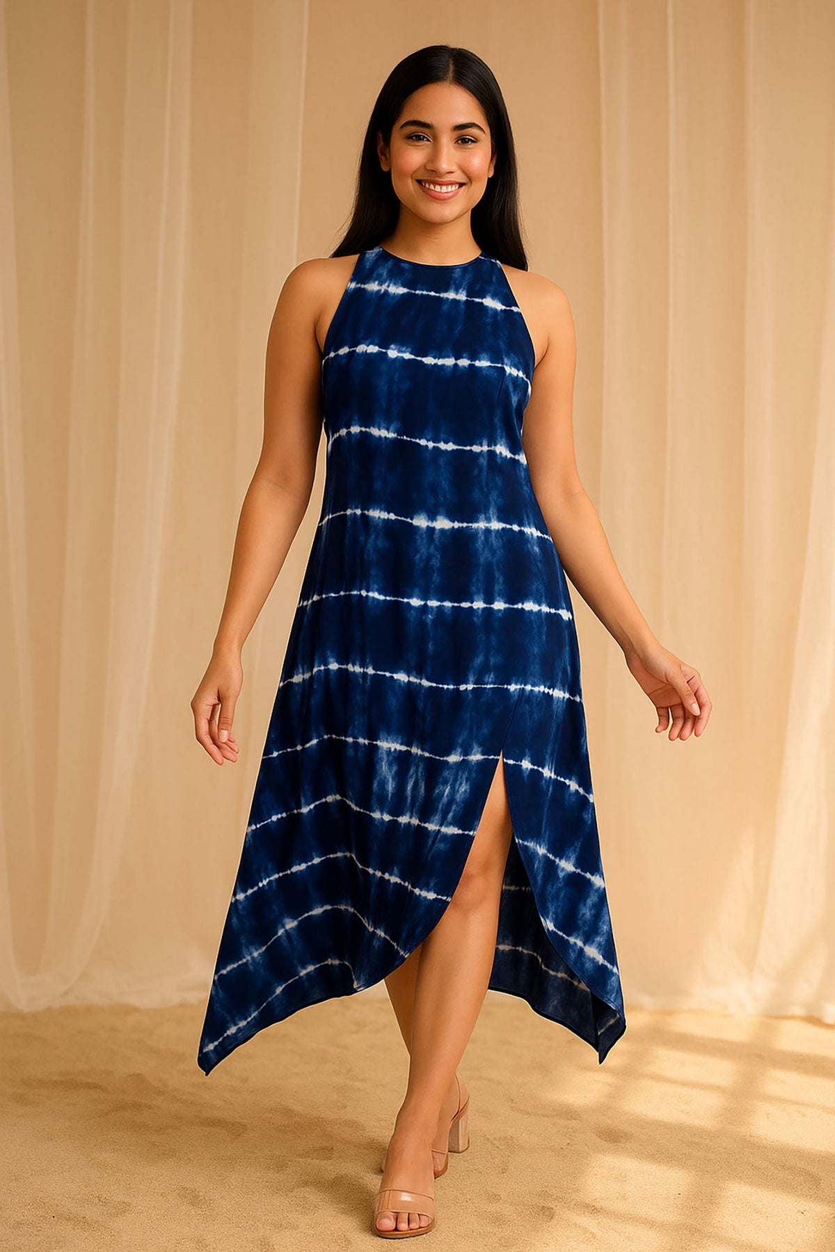 Model in navy tie-dye sleeveless midi dress with asymmetrical hem and slit, angled front view.