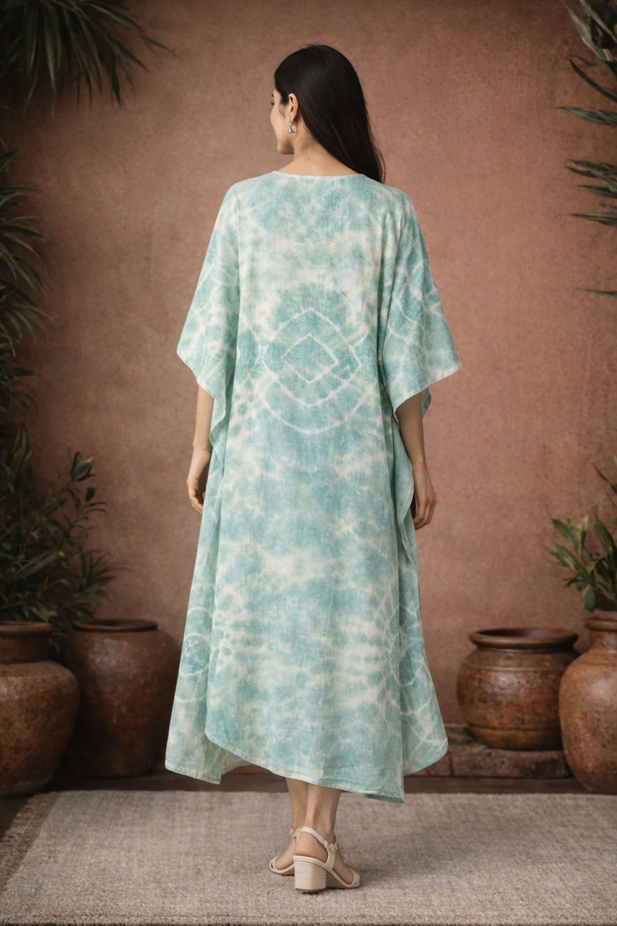 Woman wearing mint green tie dye kaftan dress back view highlighting loose drape and comfortable fit