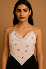 White halter crop top with red star print and draped neckline, close-up detail of fabric and design.
