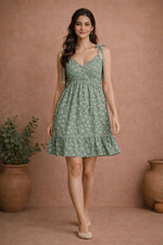 Women’s sage green floral rayon mini dress front walking pose with tie-up shoulder straps and flared hemline