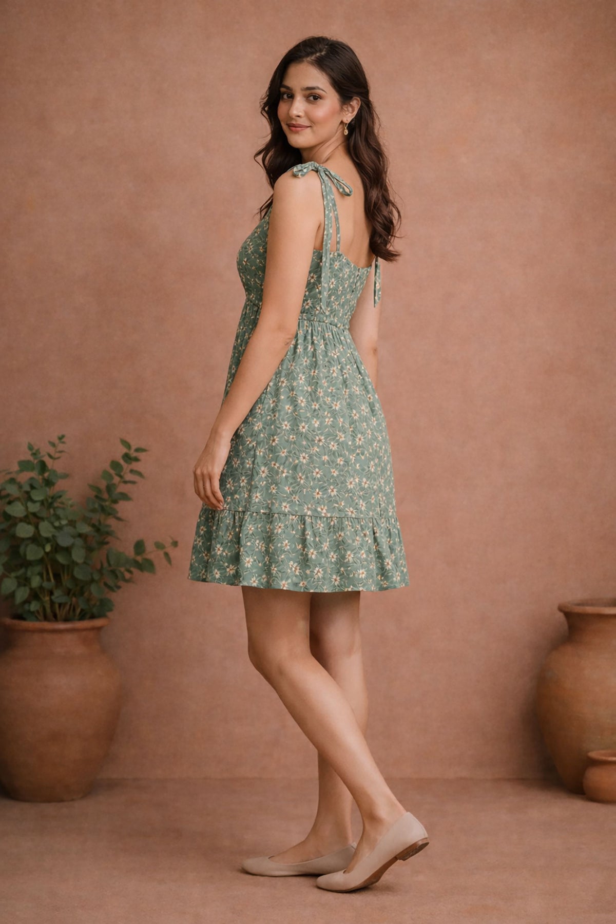 Women’s sage green floral rayon mini dress side left view with tie-up shoulder straps and flared hemline