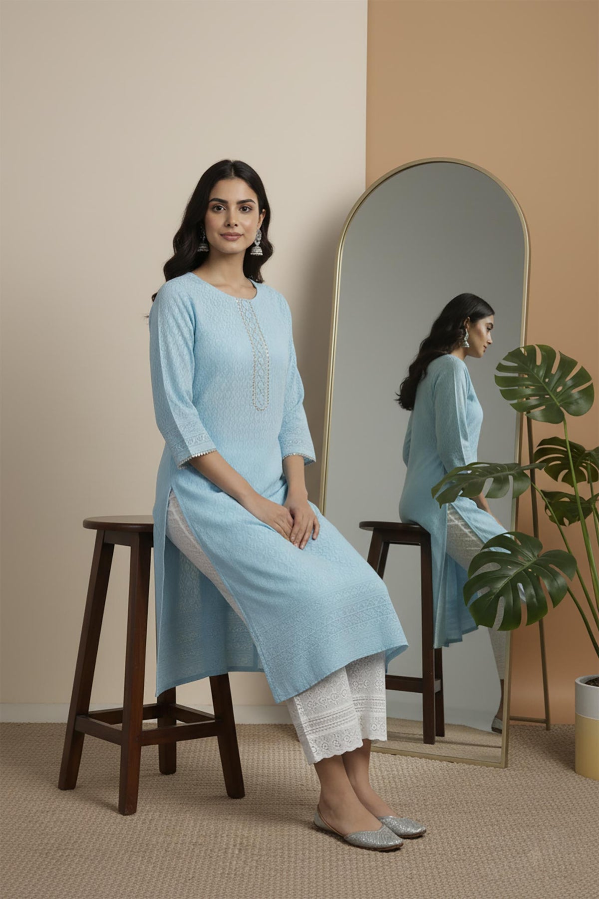 Sky blue cotton kurta set seated view highlighting straight fit, side slit and silver flats styling.