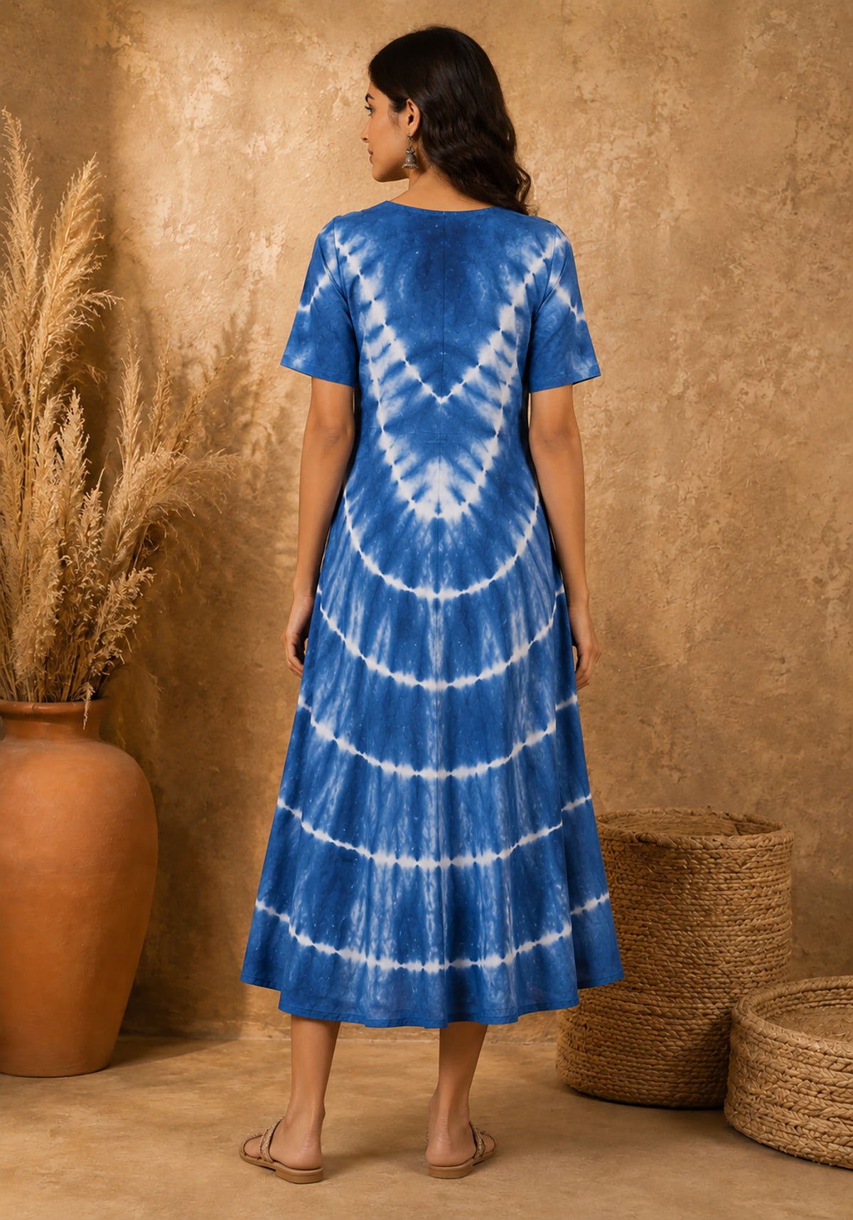 Back view of women's blue tie-dye A-line midi dress featuring symmetrical chevron pattern and clean back finish.