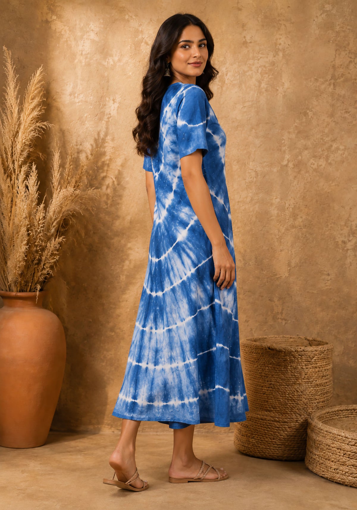 Side view of women's blue tie-dye A-line midi dress highlighting silhouette, sleeve length, and drape.