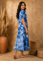 Side view of women's blue tie-dye A-line midi dress highlighting silhouette, sleeve length, and drape.