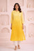 Woman wearing yellow cotton dobby ombre embroidered kurti with white pants and beige heels, walking front view