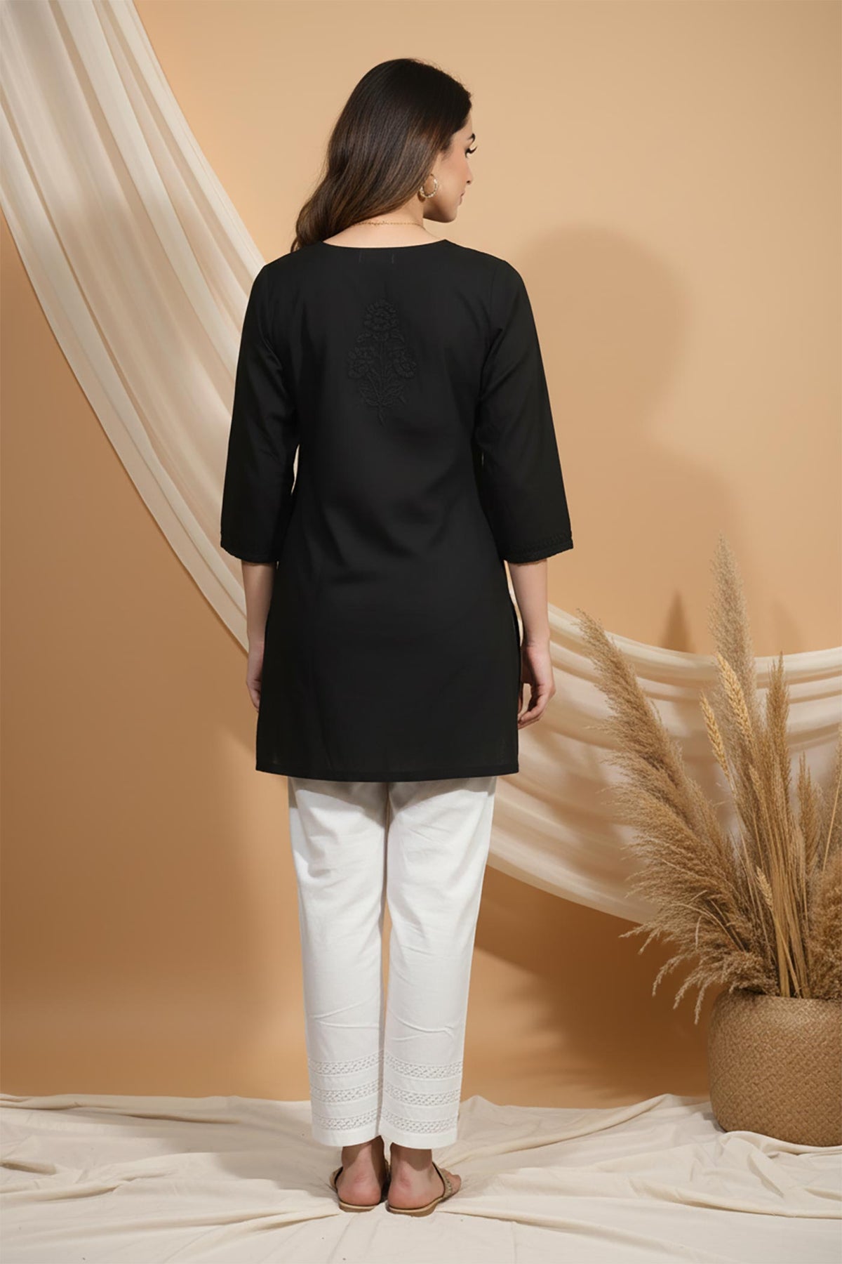 SN252 women’s black cotton embroidered short kurti featuring minimal back motif and three-quarter sleeves, back pose.