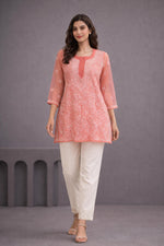 SN256 women’s coral orange organza short kurti walking pose with lightweight fabric and embroidered detailing