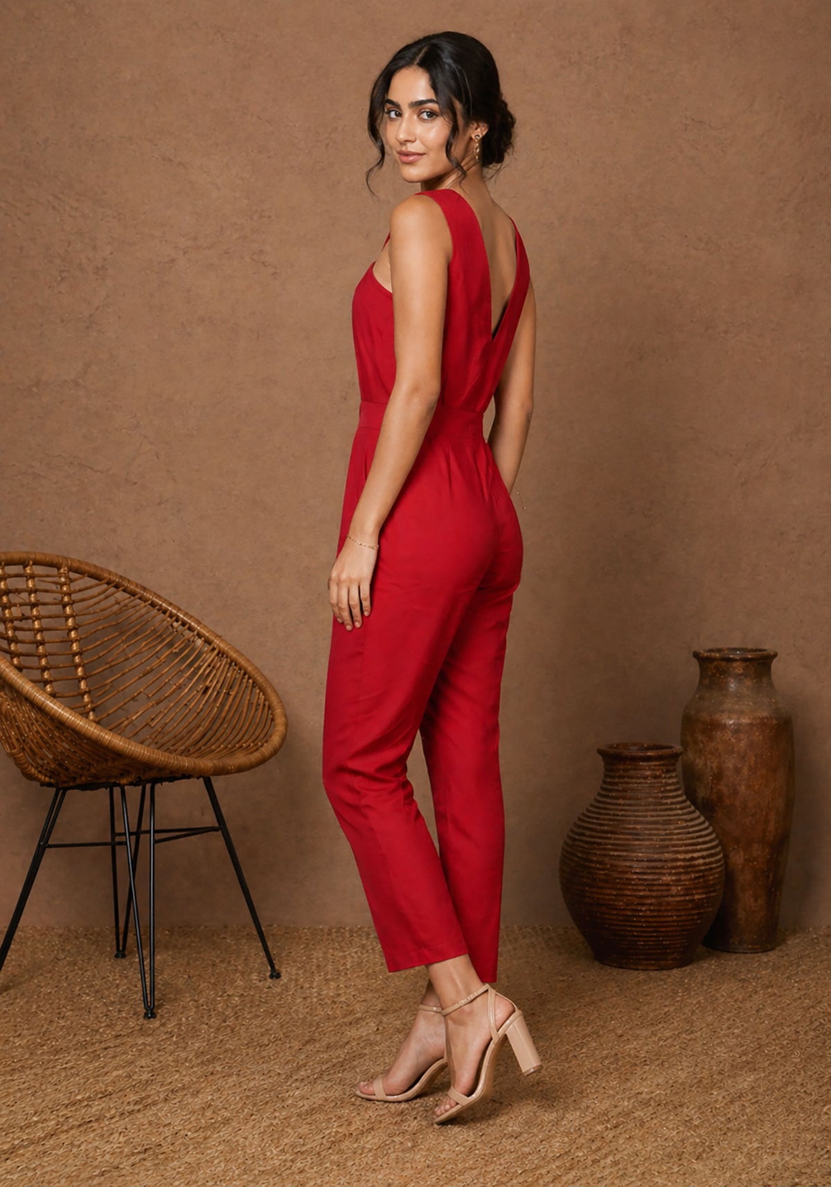 SN28 women’s red sleeveless crisscross neck jumpsuit side pose with tailored silhouette
