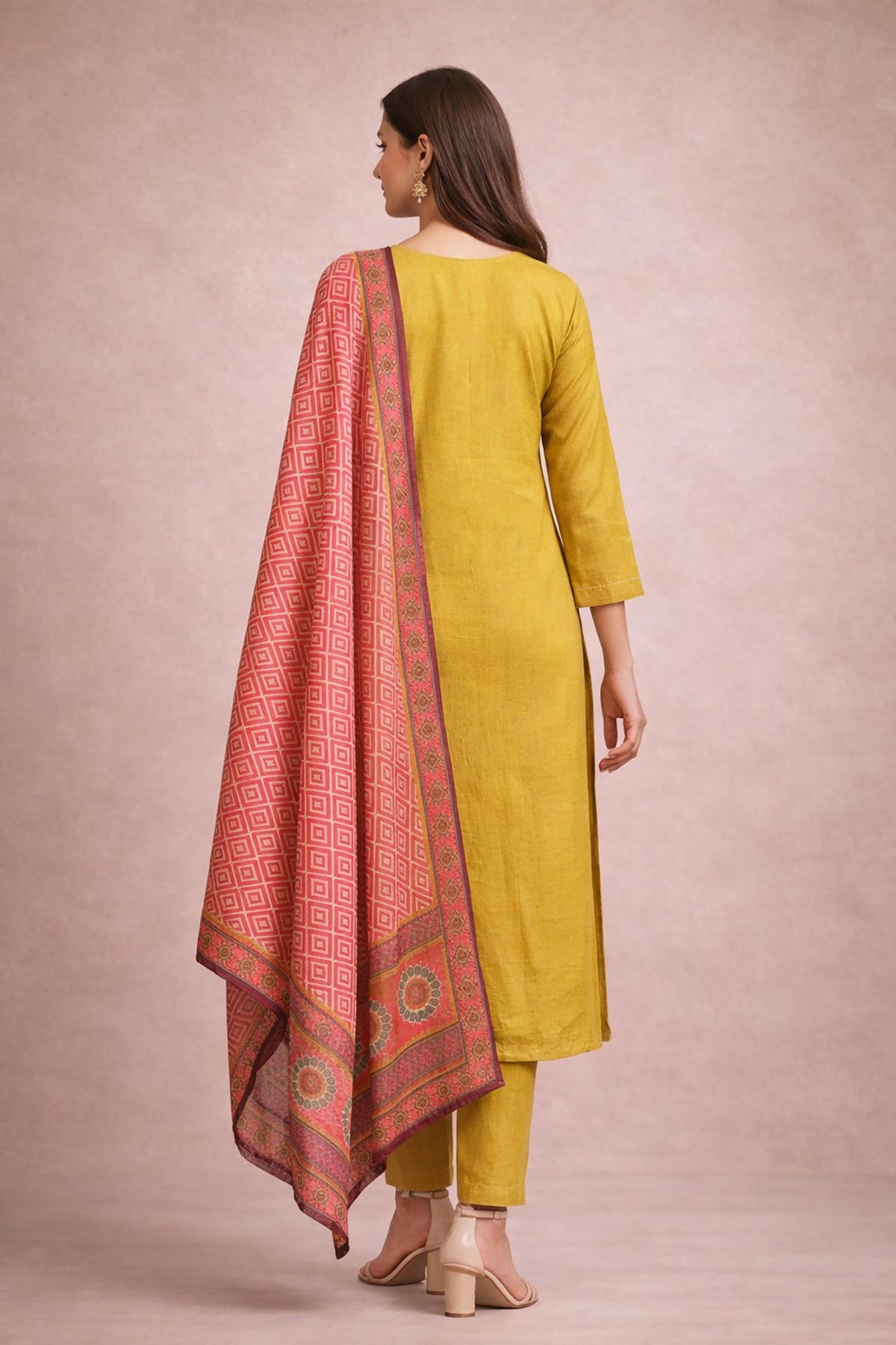 Mustard yellow kurta set with plain back, pink printed dupatta draped, back view with block heels