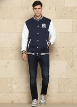 SN365 men’s navy cotton blend varsity jacket long sleeve walking pose styled with dark jeans and sneakers