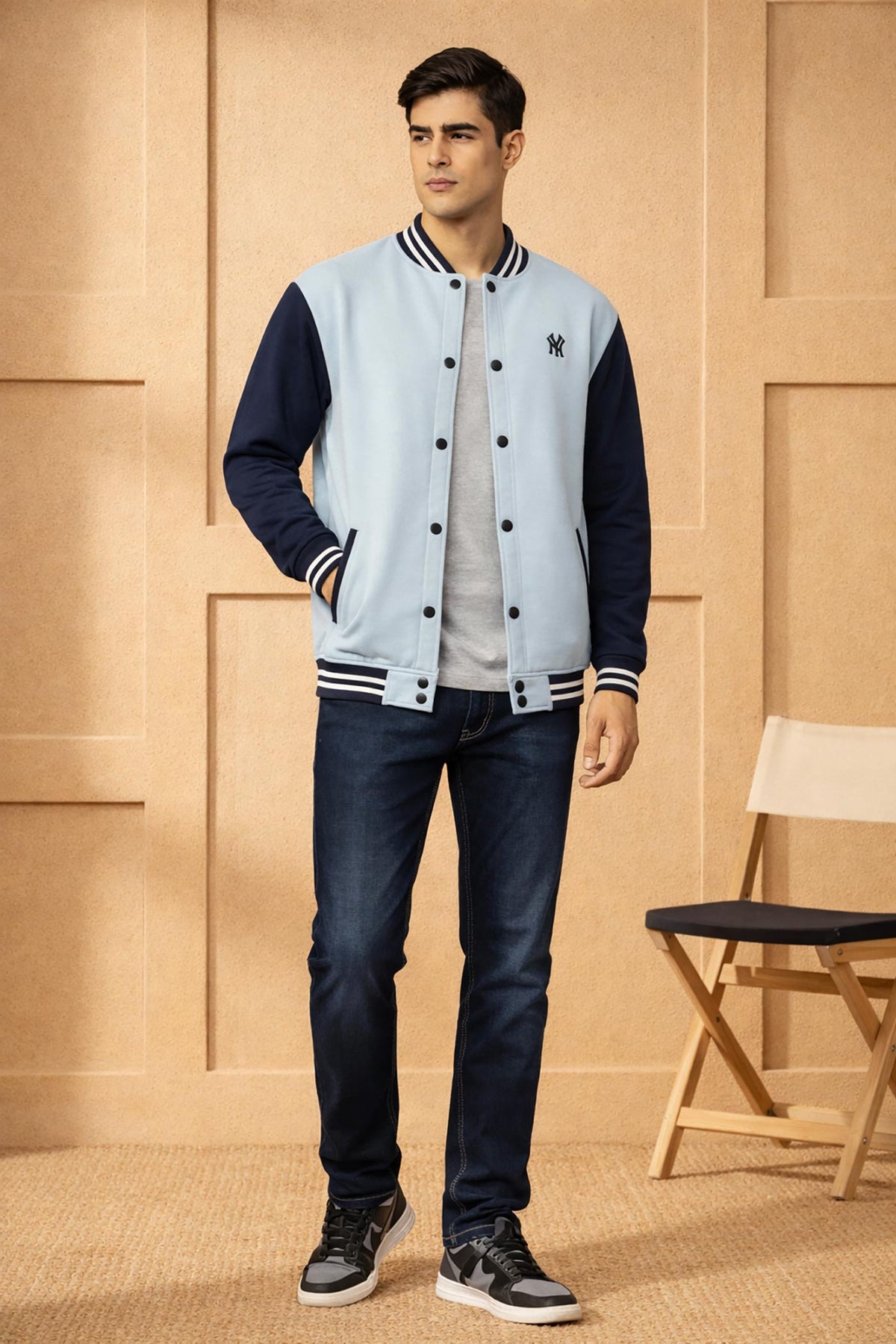 SN366 men's powder blue and navy varsity bomber jacket, long sleeve slim fit with snap buttons, front pose with denim styling