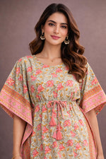Close-up of woman wearing pastel green and pink floral cotton kaftan dress with tie-up waist and tassel details