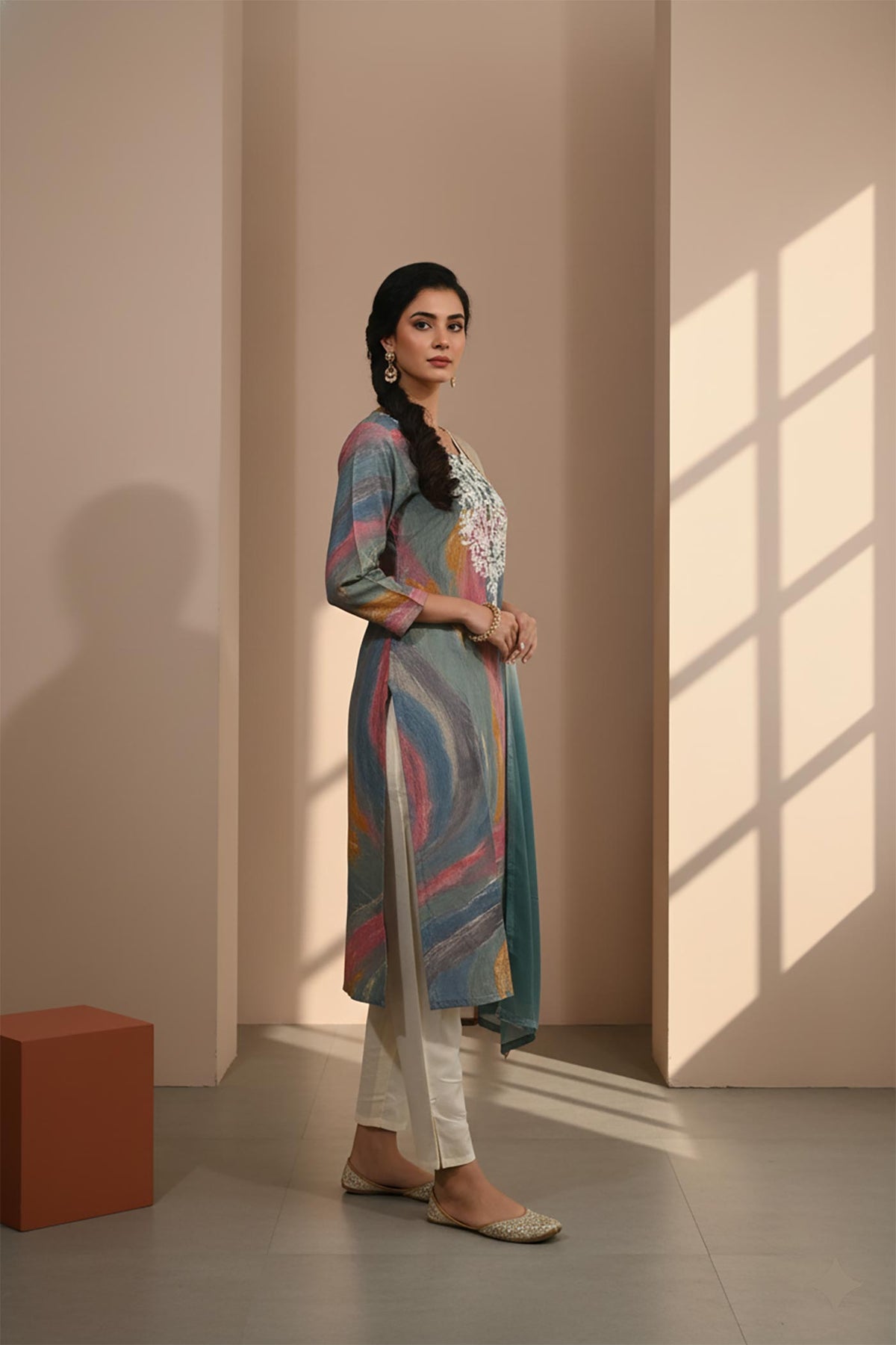 Teal multicolor printed kurta set with side slit, straight fit, ivory pants and embellished juttis, side angle.