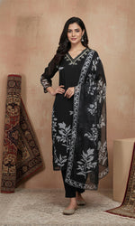 Black botanical print kurta set with embroidered V-neck, sheer sleeves, straight pants, styled with juttis.