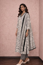 Off-white cotton kurta set with floral print and bordered dupatta, angled side view with heels.