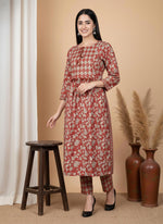 Front view terracotta floral kurta pant set with diamond yoke panel, three-quarter sleeves, styled with black heels.