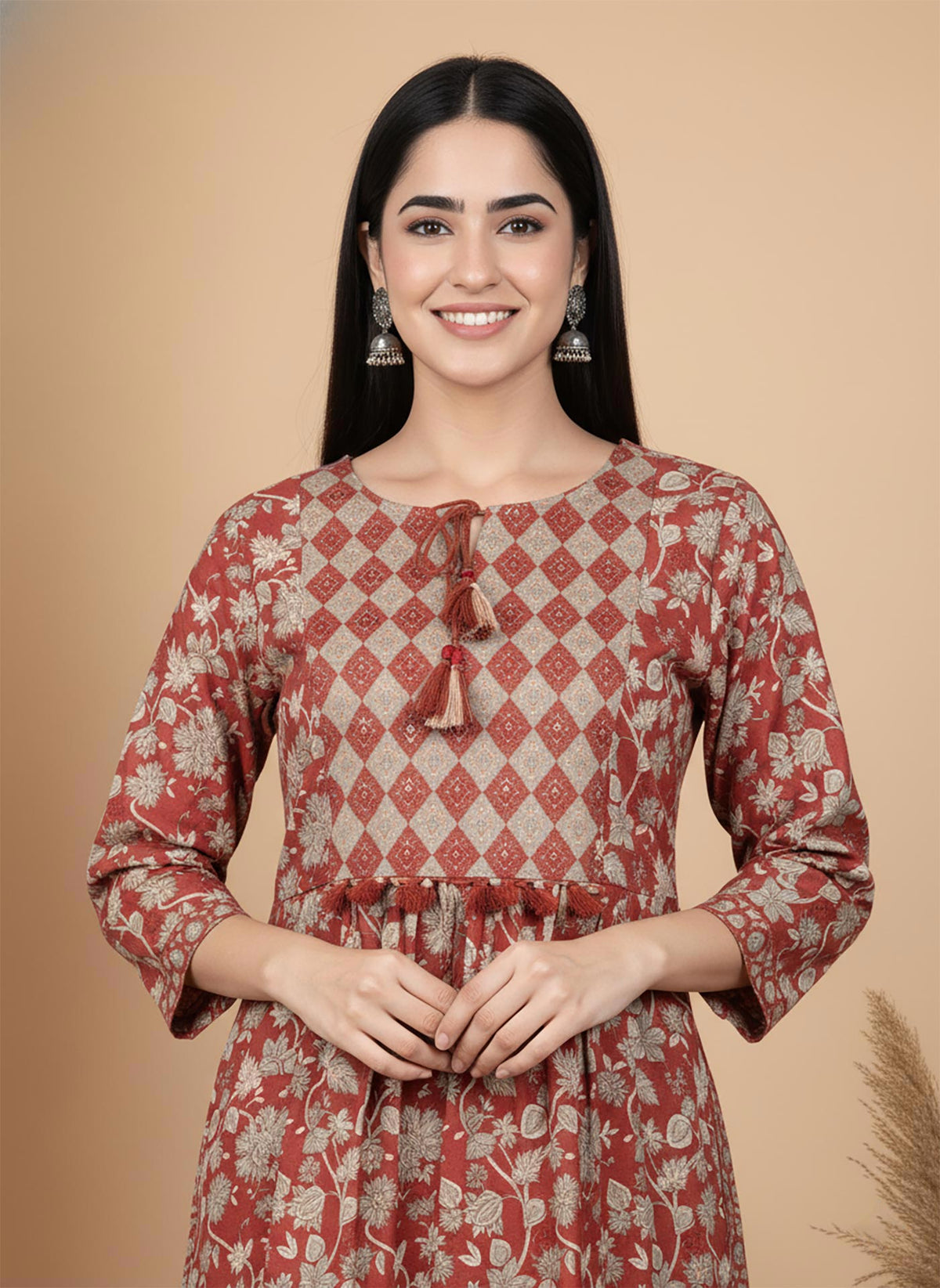 Close-up terracotta kurta diamond yoke with tassel tie-up neckline and floral print fabric.