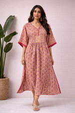 Front view of pink and mustard cotton handblock print kaftan dress with V-neck, empire waist panel and flowing silhouette