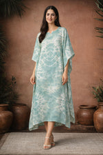 Woman wearing mint green tie dye kaftan dress with relaxed fit and flowy silhouette